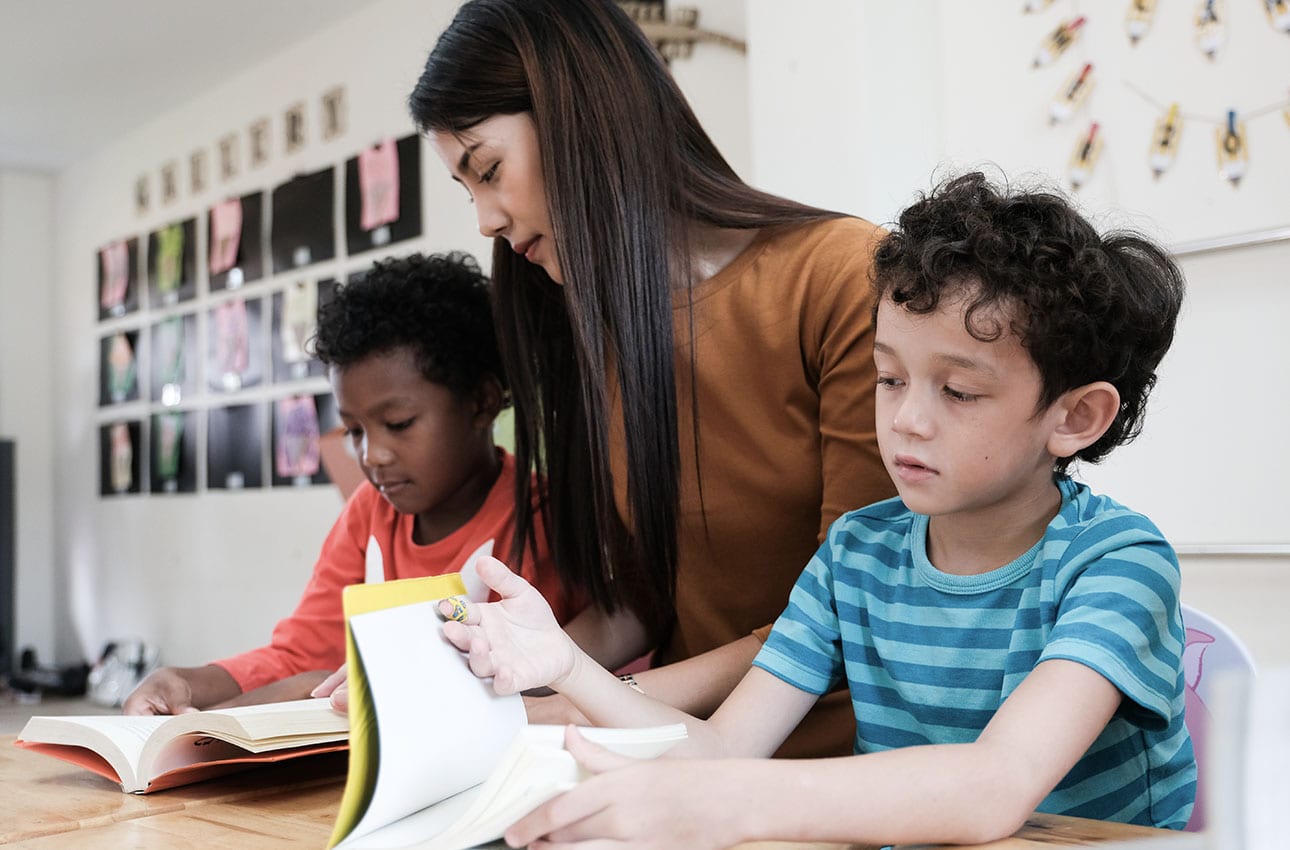 Teacher assisting her students in reading