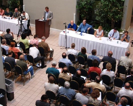 image of panel discussion with man talking at podium