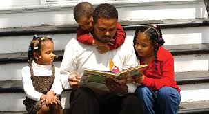 A father reading a book to his children