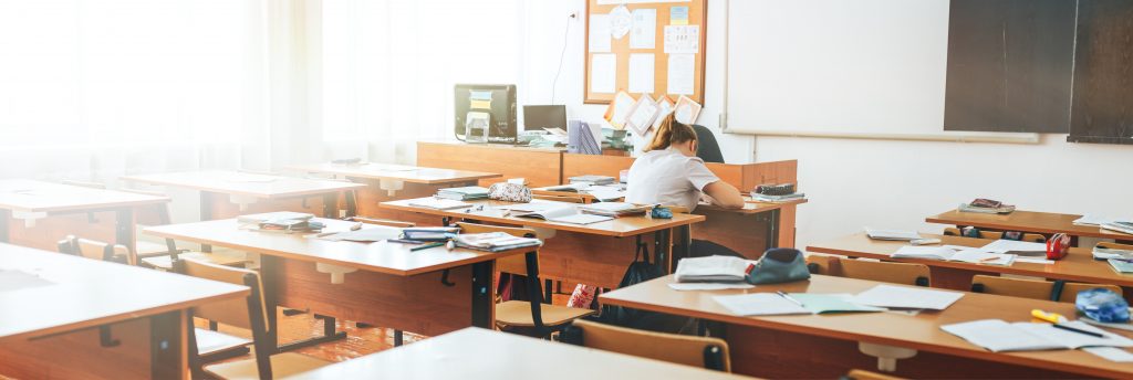 Empty classroom with school supplies, black board, long banner